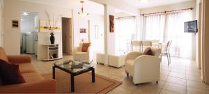 納塔爾的住宿－公寓村酒店，客厅配有桌椅,客厅配有椅子和桌子。