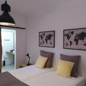 1 dormitorio con 1 cama blanca y 2 almohadas amarillas en Clube Vilarosa en Portimão