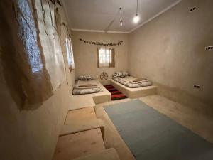 a room with two beds in it with a window at Thraa - ثراء in Siwa