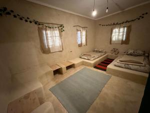 a bedroom with two beds and a rug at Thraa - ثراء in Siwa