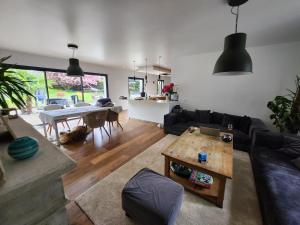 uma sala de estar com um sofá e uma mesa em Villa entière 200m² em Saint-Nom-la-Bretêche