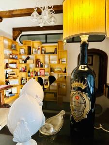 a bottle of wine sitting on a table with a lamp at Leone de Castris Wine Hotel in Salice Salentino