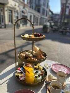 uma bandeja de três níveis de comida para o pequeno-almoço numa mesa em Parade Elluf em Venlo