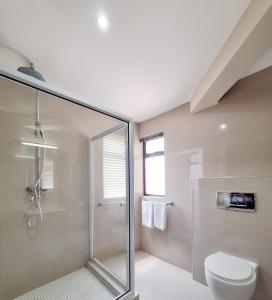 La salle de bains est pourvue d'une douche en verre et de toilettes. dans l'établissement Camere da Letto- Hotel-On-The Beach Self Catering, à Swakopmund