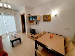 a living room with a table and a television at VISTAMAR DREAMS, 1º LINEA PLAYA AMPLARIES in Oropesa del Mar