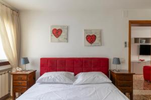 a bedroom with a red headboard and two hearts on the wall at San Marco in Venice