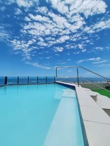 una piscina en la parte superior de un edificio con cielo azul en Camere da Letto- Hotel-On-The Beach Self Catering, en Swakopmund