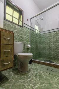 e bagno con servizi igienici e doccia in vetro. di Casa em Araçatiba - Maricá RJ a Maricá