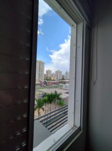 a window in a room with a view of a city at Quarto em apartamento em Cuiabá in Cuiabá