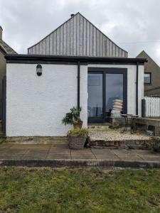 a white house with a window and a table at Craigmile Cottage in Fraserburgh