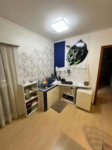 um quarto com uma cozinha com um lavatório e uma mesa em Apartamento Central - Andar alto em Joinville
