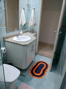 a bathroom with a toilet and a sink and a shower at Quarto em apartamento em Cuiabá in Cuiabá