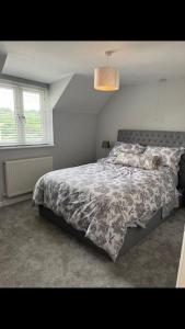 a bedroom with a bed with a comforter on it at The Annex at Kronstad in Stroud