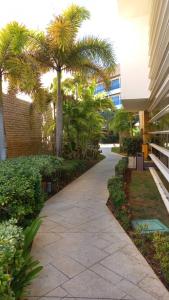 une passerelle avec des palmiers et un bâtiment dans l'établissement PH1401 Hotel Margarita Real, à Porlamar