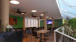 una sala da pranzo con tavolo, sedie e TV di PH1401 Hotel Margarita Real a Porlamar