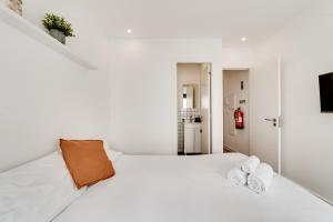 a white bedroom with a white bed with two towels at Lapa Stylish Apartments in Lisbon