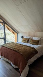 - une chambre avec un grand lit et une grande fenêtre dans l'établissement Chalet Coste Belle, à La Fare-en-Champsaur