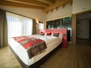 um quarto com uma cama grande e uma cabeceira vermelha em Chalet Dolce Vita em Livigno