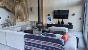 a living room with two couches and a tv at Chalet Coste Belle in La Fare-en-Champsaur