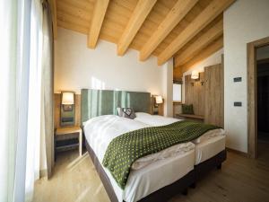 um quarto com uma cama grande num quarto com tectos em madeira em Chalet Dolce Vita em Livigno