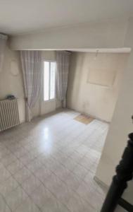 una stanza vuota con pavimento piastrellato bianco e finestra di Maison entière équipée 220m2 a Clamart