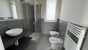 a bathroom with a sink and a toilet and a shower at Polinesia 1 in Lido delle Nazioni