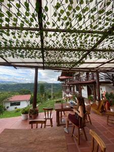 a woman sitting at a table on a patio at Antahkarana Casa Hotel in San Agustín