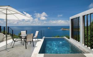 a patio with a table and chairs and a swimming pool at Philip's Villa in Koh Tao