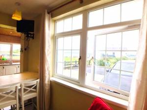 a kitchen with a large window with a table and a view at Rossnowlagh Creek Chalet 6 in Rossnowlagh
