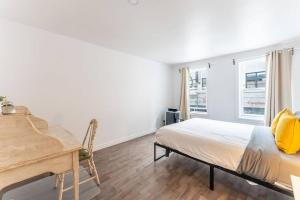 a bedroom with a bed and a desk and window at Le Alexis, A stay in the heart of the City ! in Quebec City +23 photos