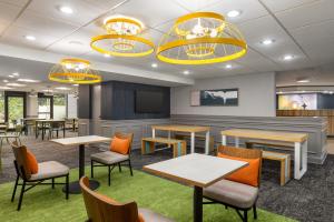 une salle à manger avec des tables, des chaises et des lumières dans l'établissement Spark by Hilton Sarasota Siesta Key Gateway, à Sarasota