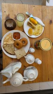 Blue Tides Hotel في نونغوي: طاولة خشبية عليها صحون طعام الافطار