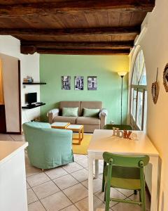 un soggiorno con tavolo e divano di -Ortaflats- Appartamento l'Isola a Orta San Giulio