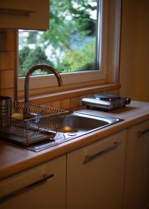 Una encimera de cocina con un fregadero y una ventana. en Słoneczne Wzgórze DOMEK, en Szczawnica