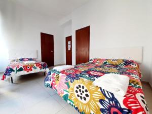 um quarto com 2 camas e cobertores coloridos em Arc House Ribera Only Adults em Córdoba