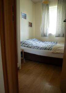 Un dormitorio pequeño con una cama con ventana. en Słoneczne Wzgórze DOMEK, en Szczawnica