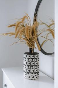 a black and white vase with a plant in it at St Benedicts Street Flat with Roof Terrace in Norwich