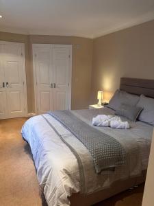 a bedroom with a large bed and a lamp at Max's Woodland Lodge in Bridlington