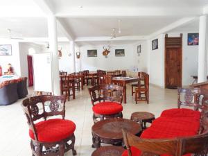 a dining room with tables and chairs and red seats at Wellawaya Rest House in Wellawaya