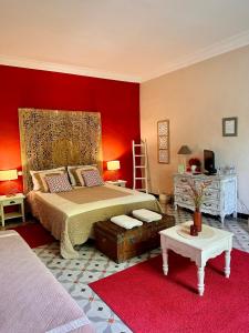 1 dormitorio con cama y pared roja en Lacanepière, en Générac