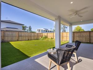d'une terrasse avec une table, des chaises et une cour. dans l'établissement 2024 Brand-new 5BR Comfort House in SunnybankHills, à Brisbane