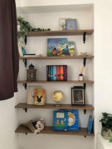 een muur met planken gevuld met boeken en foto's bij The Librarian's home in San Gimignano