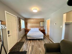 a bedroom with a bed and a couch and a door at Alpenrose , hottub, Big Deck, Mountain Views in Golden