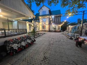 a house with couches sitting in a courtyard at night at Green West House in Bishkek