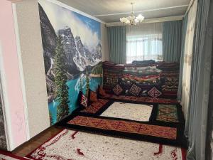 Schlafzimmer mit einem Bett mit Wandgemälde in der Unterkunft Green West House in Bischkek