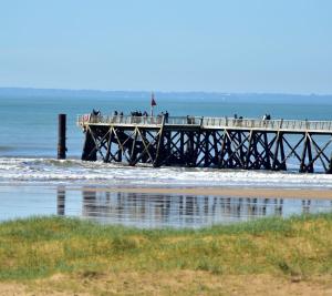 un muelle con gente parada en el océano en Studio Bords de plage, en Saint-Jean-de-Monts