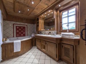 ein großes Badezimmer mit zwei Waschbecken und einer Badewanne in der Unterkunft Duplex de Charme à Courchevel 1850 - Capacité 10 Personnes, Centre-Ville - FR-1-575-29 in Courchevel + 12 Fotos