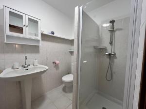 un bagno con doccia, lavandino e WC di Maison de village vue mer et montagne a Sari Solenzara Altre 5 foto