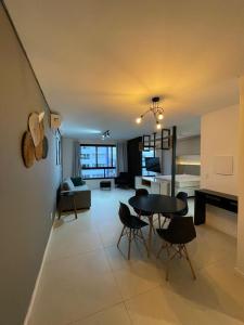 a large living room with a table and chairs at Vesta - melhor localização Torres in Torres