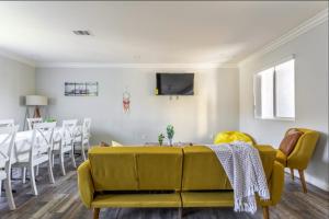 a living room with a yellow couch and a table at Cheerful 5BR house with parking near USC in Los Angeles